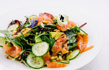 Fresh salmon and spinach salad on white plate