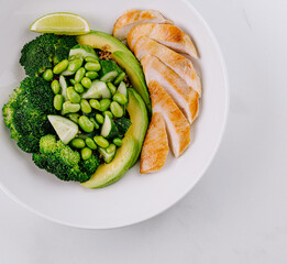 Healthy grilled chicken plate with vegetables and lime