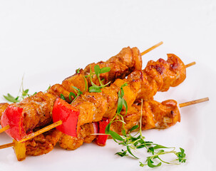Juicy grilled chicken skewers on white plate