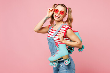 Side view young happy woman she wear red t-shirt denim overalls casual clothes glasses hold blue...