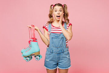Young shocked surprised amazed woman she wear red t-shirt denim overalls casual clothes hold blue...