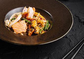 Gourmet seafood stir fry on elegant dark plate