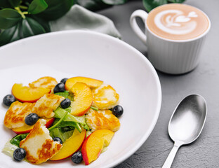 Fresh fruit salad with halloumi cheese and coffee