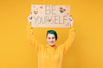 Young lesbian woman with dyed green hair wear hoody casual clothes hold cardboard with be yourself...