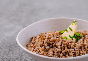 Healthy cooked buckwheat in bowl with butter