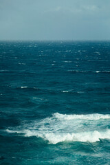 Moody stormy blue ocean with windy onshore waves and whitecaps captured from high above