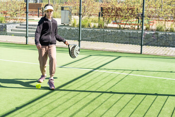 Obraz premium little girl playing padel and hitting the ball with his racket outdoors sports concepts