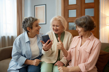 Retired women friends looking on smartphone screen