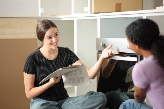 Two women installing a furnace in the kitchen