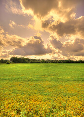 Big clouds lit up by the sun floating over a rural landscape in The Netherlands.