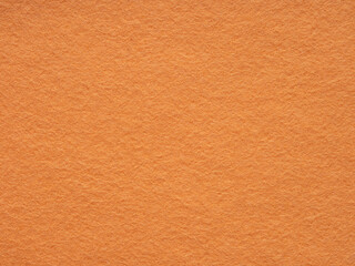Warmth radiates from the vibrant orange felt, inviting a touch with its textured simplicity