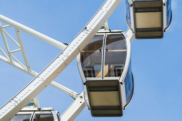 Closer detail of a Ferris wheel gondola cabin with a blue sky