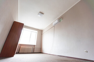 Empty room with all white walls and parquet floor. Nobody inside the room.