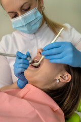 Dentist woman use dental drill while treating patient in the dental office