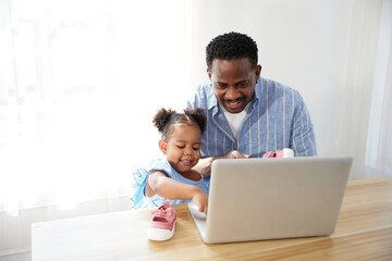 Father doing online shopping and buying more shoes with daughter from laptop computer
