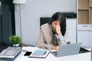 Stress businesswoman is sitting at table, under stress from working.