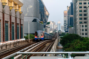 BTS Skytrain, Electric train, running on the way with business office buildings on the background.