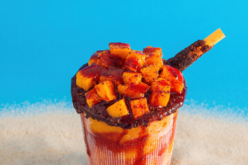 Mangonada, typical mexican mango smoothie on summer background.