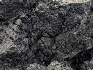 Pile of old cracked asphalt rubble close up, abstract industrial background.