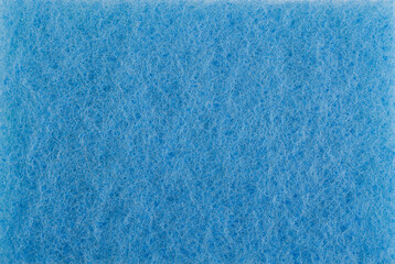 Surface of a blue cleaning sponge. Background made of blue cleaning cloth.