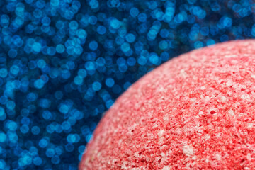 Ball of colored salt crystals on a shimmering blue background. Abstract background or backdrop....