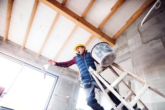 Man falling off the ladder. Accident of a man worker at the construction site. Work injury, accident in workplace.