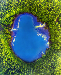 Aerial top down amazing lake of round shape. Cloudy sky reflected in clear turquoise water of pond surrounded by trees and plants. Ripple on water surface,  - Sete Cidades