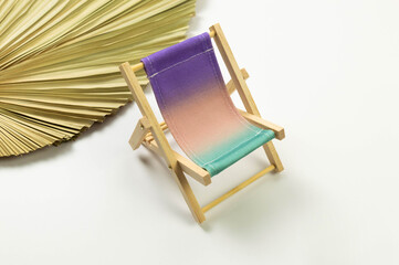 Colorful beach chair, dried palm leaf on white background. Summer, holidays and beach concept....