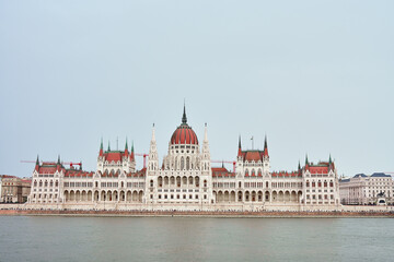 Fototapeta premium Hungarian Parliament with river Danube, front view. Famous landmark in Budapest. Beautiful architecture with historical building