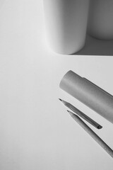 Design Studio Workspace. Paper Rolls, Sheets of Paper, Pencils on White Background. Monochrome Paper Mockup. Education Concept.                        