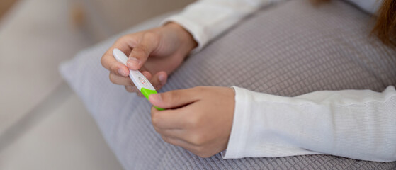 Woman examining pregnancy test results with concern. Concept of personal health, anxiety, and reproductive issues