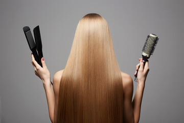 beautiful blond hair woman holding styling accessories. Back of girl with Healthy hair