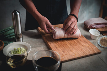 Men tie ropes and cut pork to make Japanese-style pork slices.