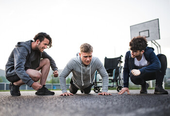 Disabled young man exercising with his supportive friends. Male friendship.