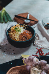 Khao Soi, a local dish of northern Thailand, is filled with various spices including lime, shallots, and chili.