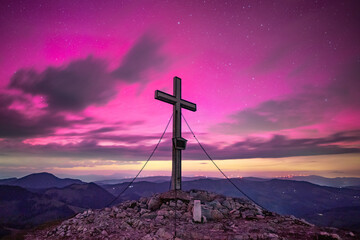 Aurora borealis on a mountain summit in Austria. Northern lights event over europe on May 10, 2024....