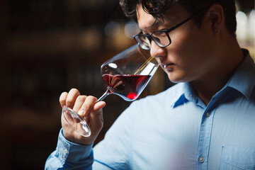 Sommelier Examining Aroma of Red Wine in Stemmed Glass at Tasting Event