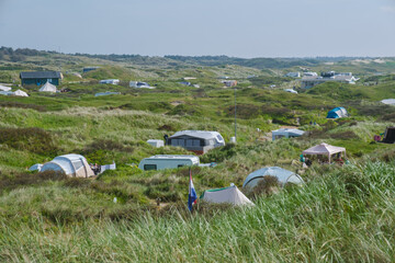 A group of tents nestled on a lush grassy hillside on the picturesque island of Texel in the...