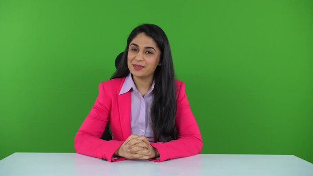 A young Indian news anchor delivering a speech on the green screen - television announcer  new reporter. A businesswoman giving a lecture during the meeting with the employees - female entrepreneur...