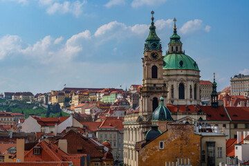 Obraz premium Church of St. Nicholas (built 1732-1737) against the backdrop of the roofs of the capital of the Czech Republic - the city of Prague