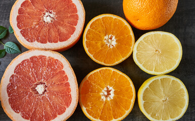 Top view of the citrus fruits orange, grapefruit and lemon on a dark background