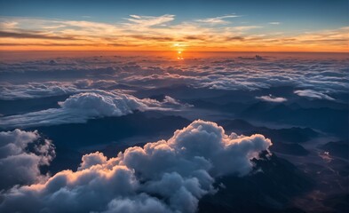 An aerial view of a mountain range with clouds at sunrise