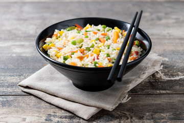 White fried rice with vegetables on wooden table