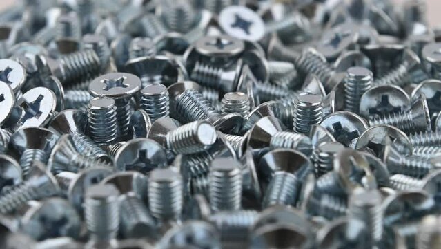 Metric countersunk bolts M6 x 10mm. Movement with rotation. Close-up, side view, small depth of field.