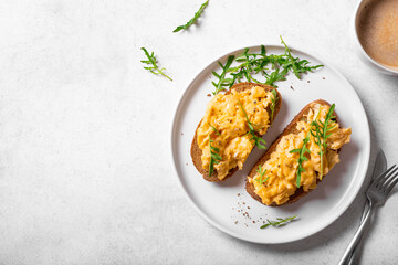 Scrambled eggs sandwiches with arugula microgreens
