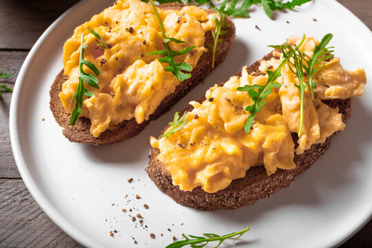 Scrambled eggs sandwiches with arugula microgreens