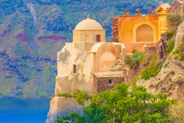 Oia Venetian castle in Santorini island and volcanic rocks, blue sea in Greece