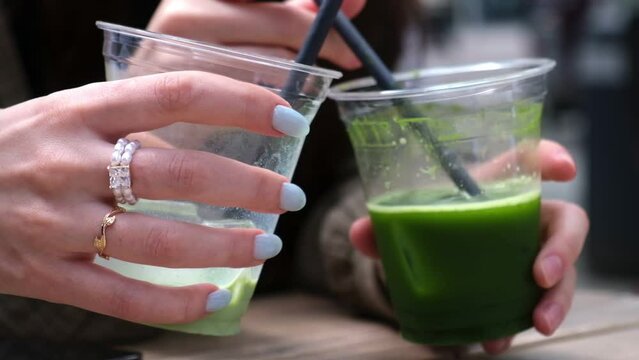 Girls chugging drinks at a coffee shop. Matcha latte in hand. Friends in a coffee shop. A group of friends in a coffee shop.
