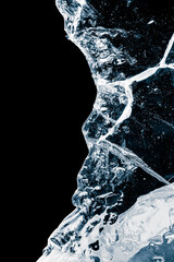 Pure transparent crushed ice piece with cracks on a black background.