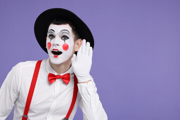 Funny mime artist showing hand to ear gesture on purple background. Space for text